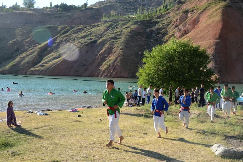 Young athletes training near mountain lake