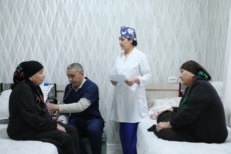 Медицинские работники, осматривающие пожилых пациентов