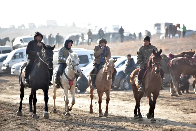 Men riding horses at outdoor event