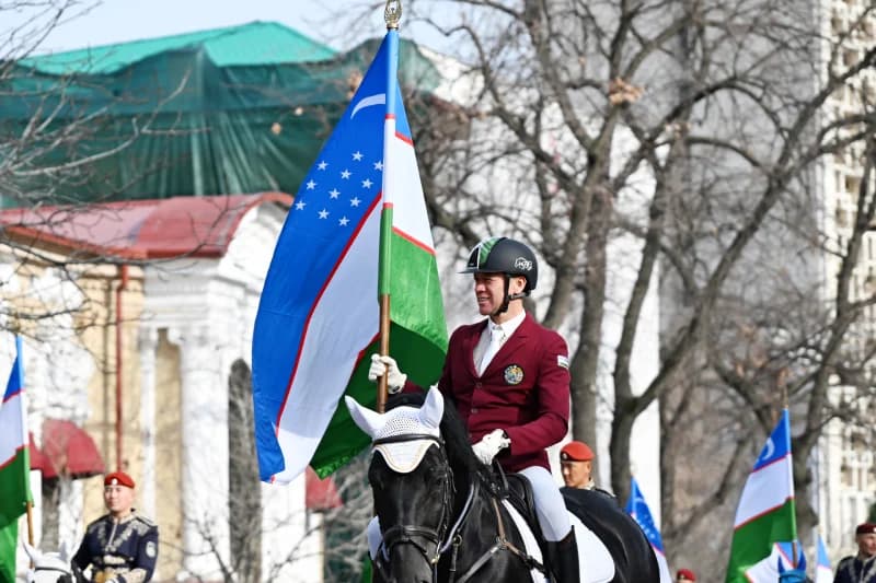 Equestrian carrying Uzbekistan flag in parade