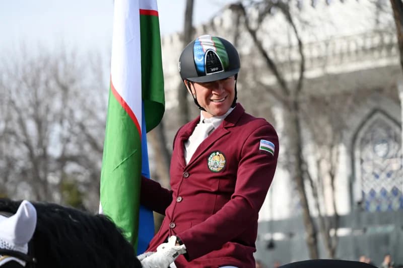 Конный спортсмен с флагом Узбекистана