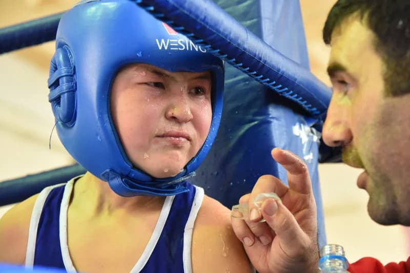 Coach Advising Young Boxer During Match