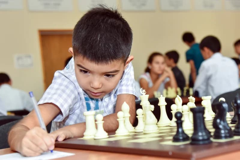 Мальчик, играющий в шахматы в классе