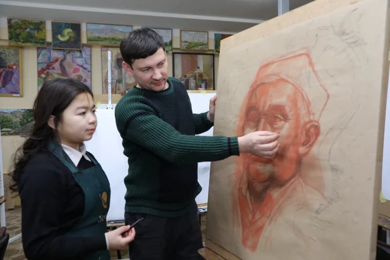Art teacher instructing student in studio