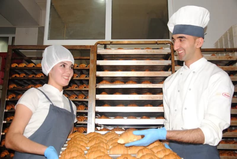 Bakers preparing fresh croissants in bakery