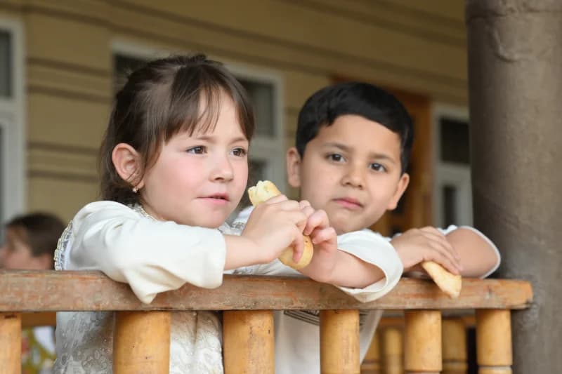 Children eating bread on porch
