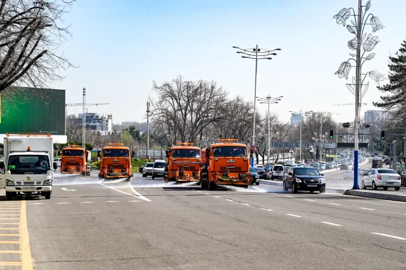 Оранжевые грузовики убирают городскую улицу