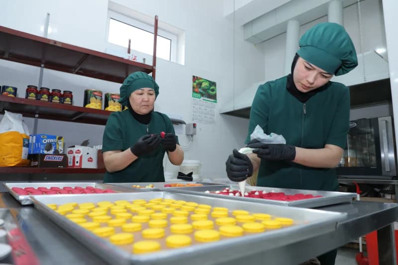Confectioners preparing colorful macaron cookies