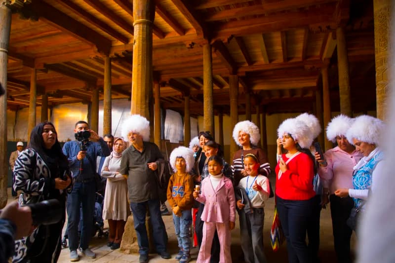 An’anaviy mo‘ynali qalpoq kiygan tashrif buyuruvchilar
