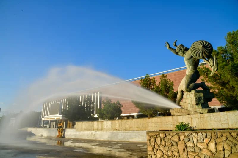 Water sprays from bronze statue fountain