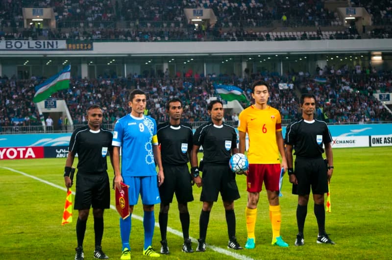 Football players and referees standing