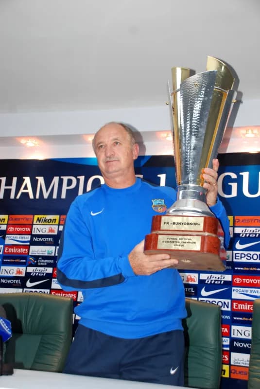 Coach holds football championship trophy