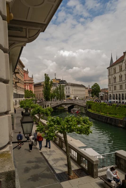People walk along river embankment