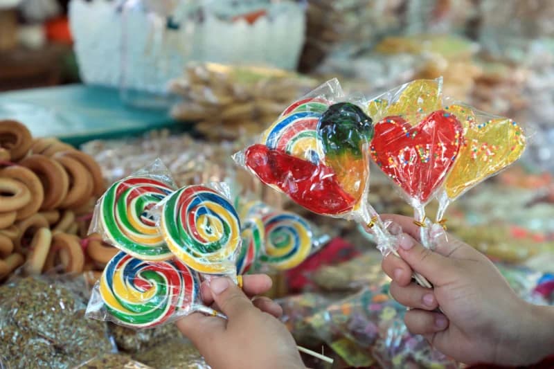 Person holding colorful sugar lollipops
