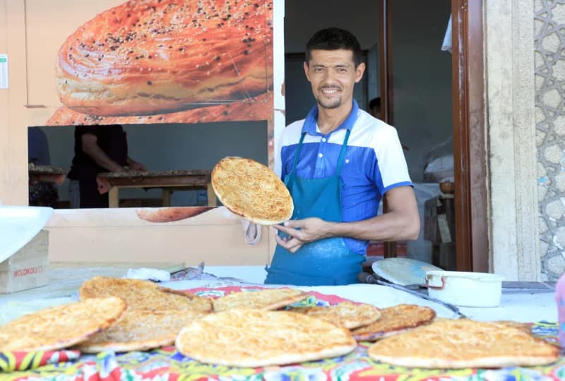 Baker displays fresh round bread