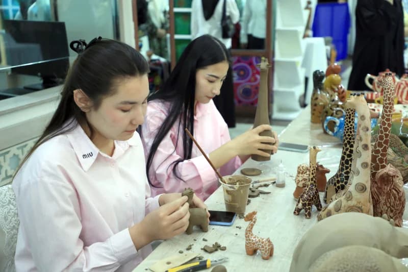 Young women crafting clay figurines