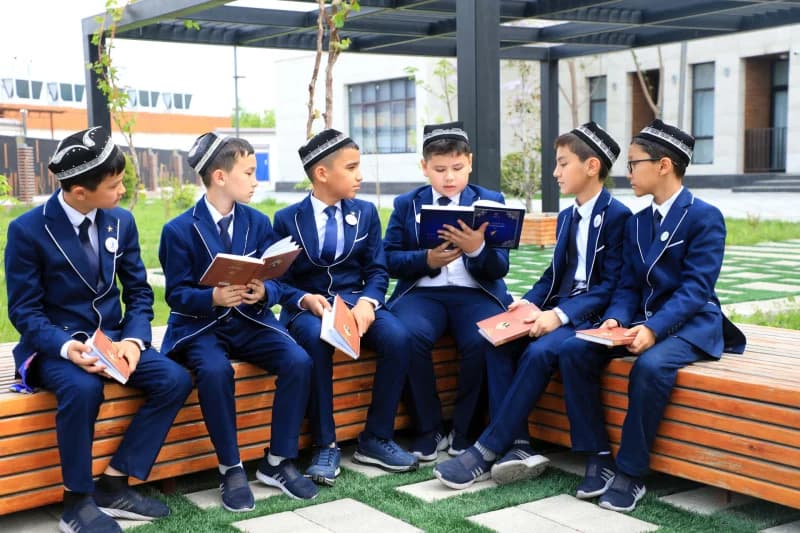 Students reading books outdoors together