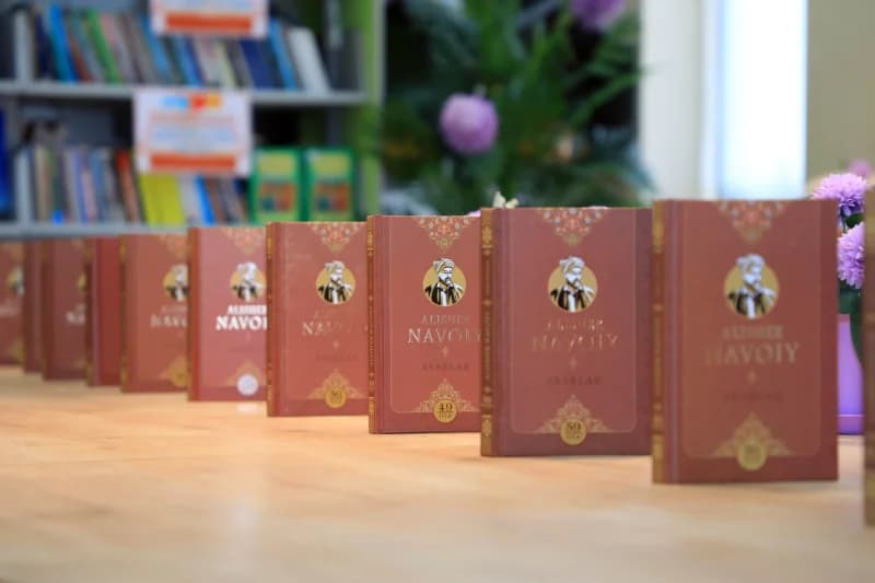 книги выстраиваются на деревянном столе