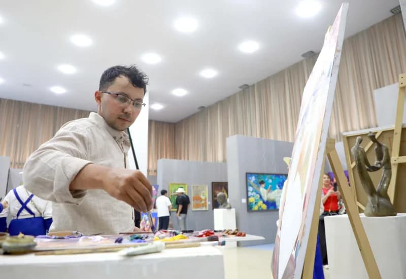 Artist painting on canvas indoors