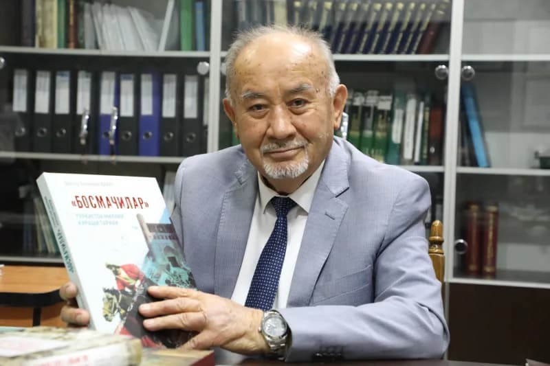 Elderly man holding historical book