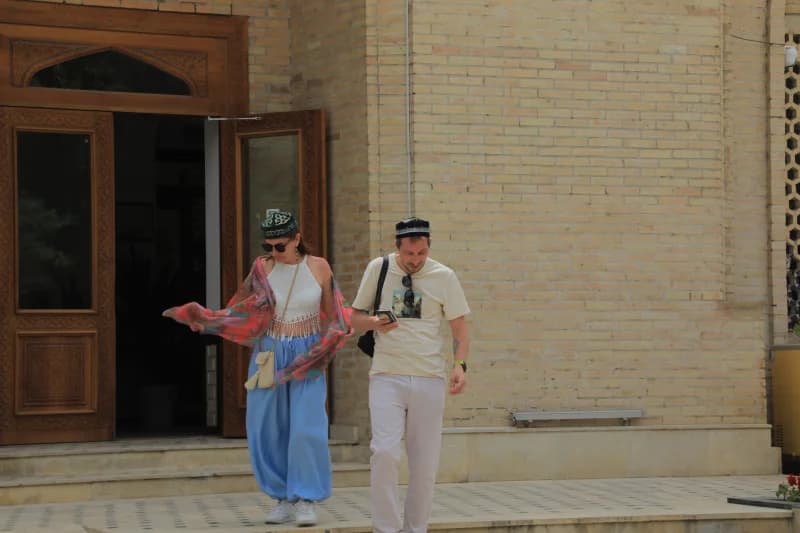 Tarixiy bino yaqinida sayr qilayotgan sayyohlar