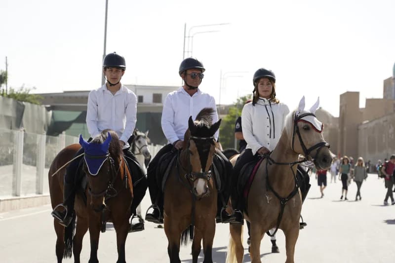 Three riders sitting on horses