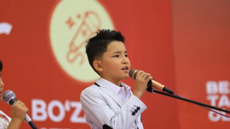 Young boy singing into microphone