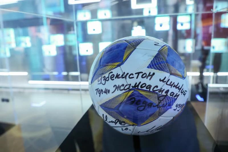 футбольный мяч с автографом сидит на выставке