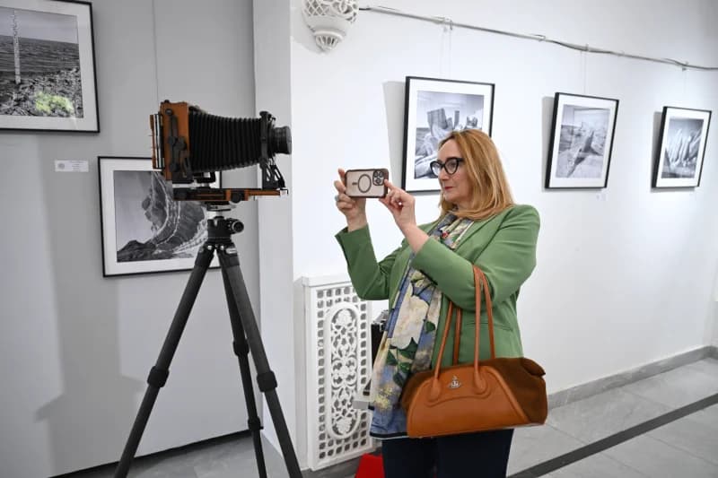 Woman photographs vintage bellows camera