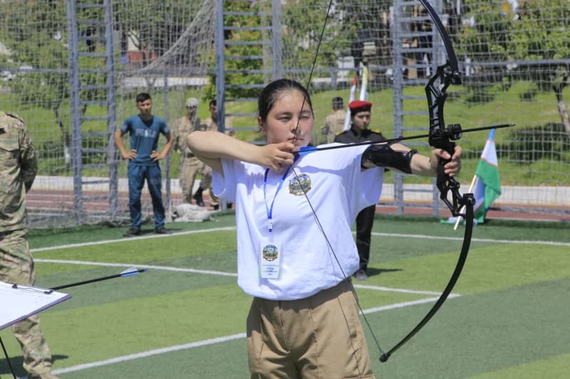 Young woman practices archery outdoors