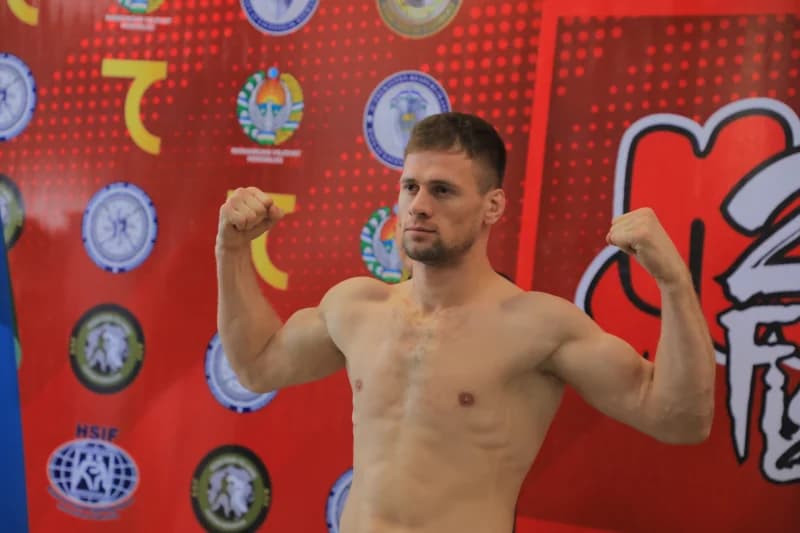 Athlete flexes muscles during weigh-in