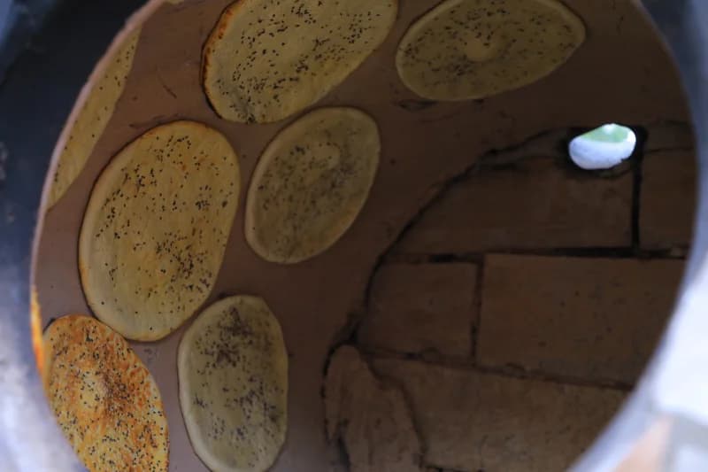 Flatbreads baking inside clay oven