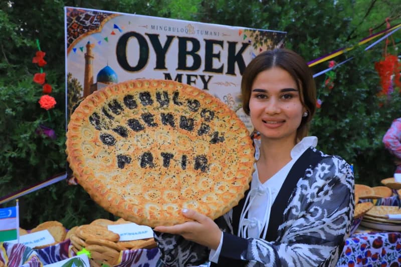 Женщина держит традиционный узбекский хлеб
