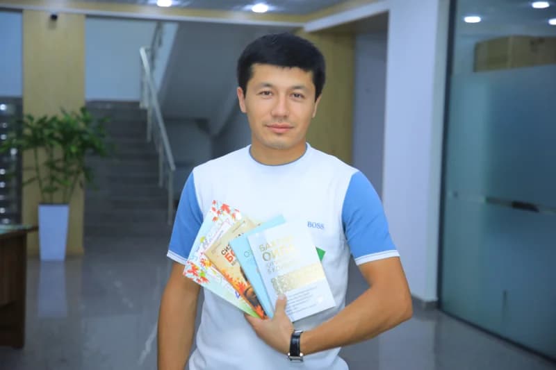 young man holding several books