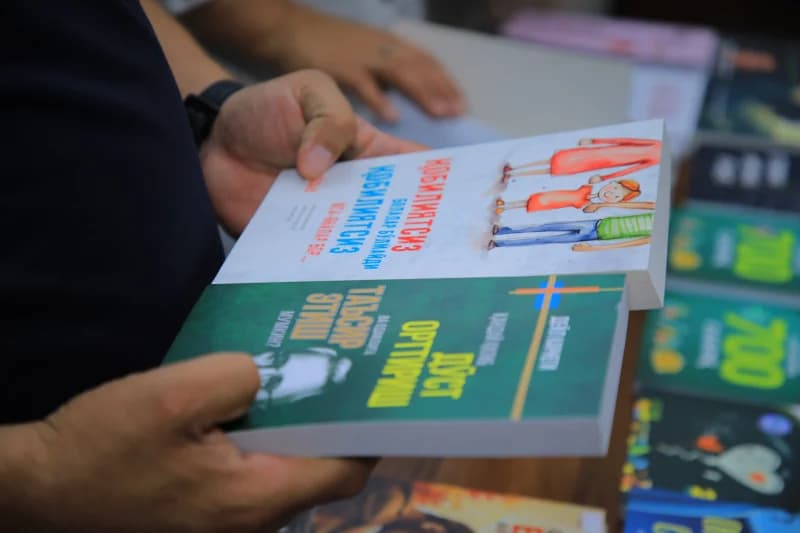 person holding two printed books