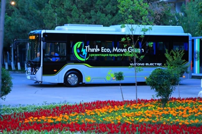 Electric bus drives through park