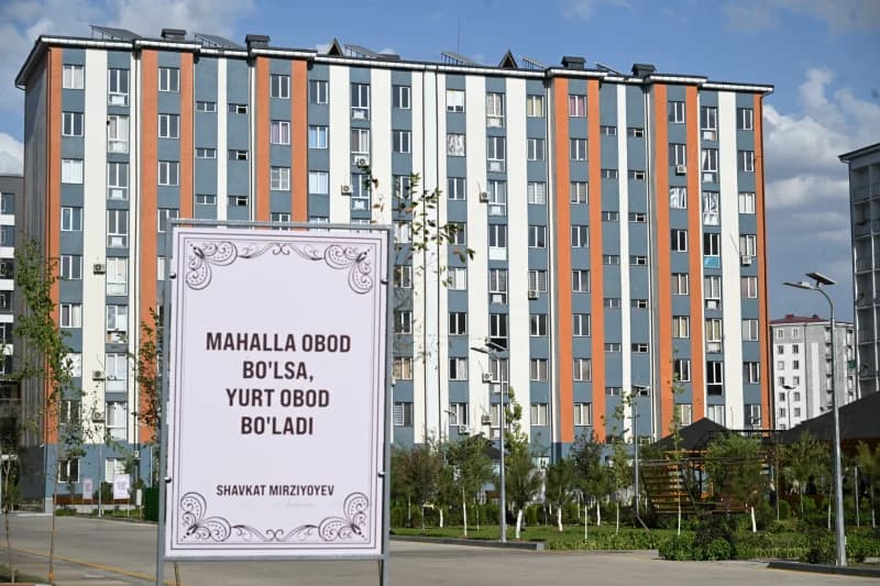 Вывеска стоит перед современными квартирами