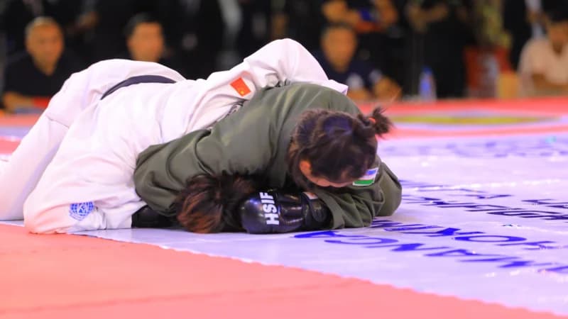 Спортсмены борются на соревновательном ковре