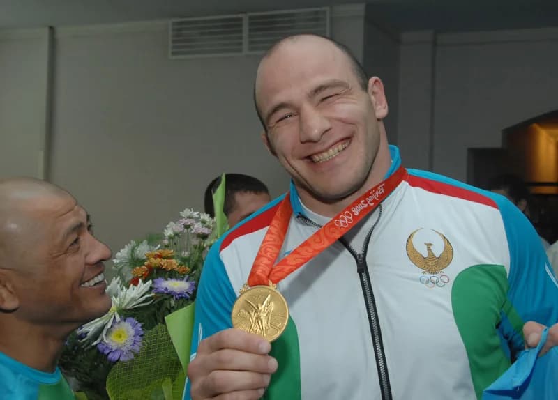 Спортсмен празднует с золотой медалью