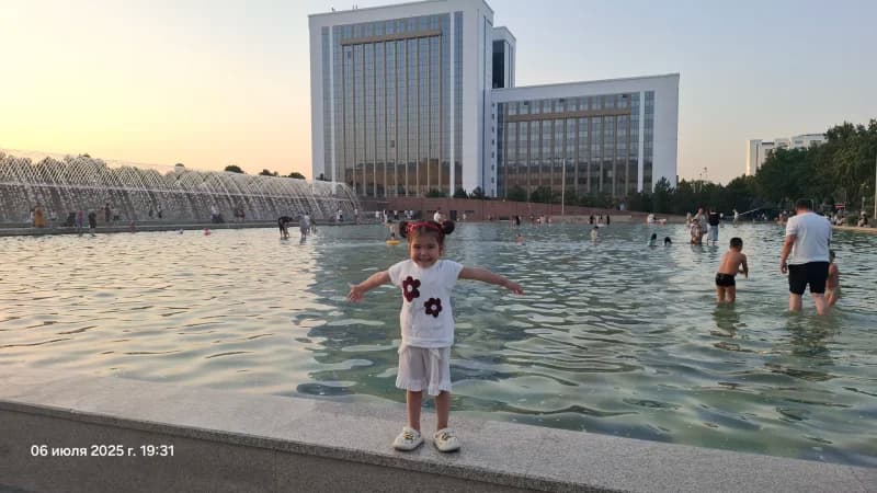Little girl smiling near fountain pool