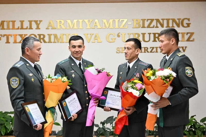 Mukofotlar va guldastalar bilan harbiy xizmatchilar