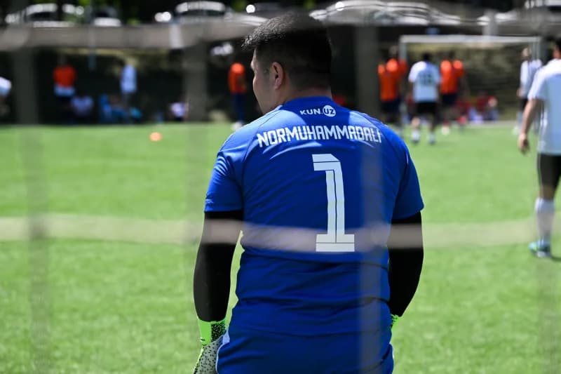 Darvozabon yashil maydonda turibdi