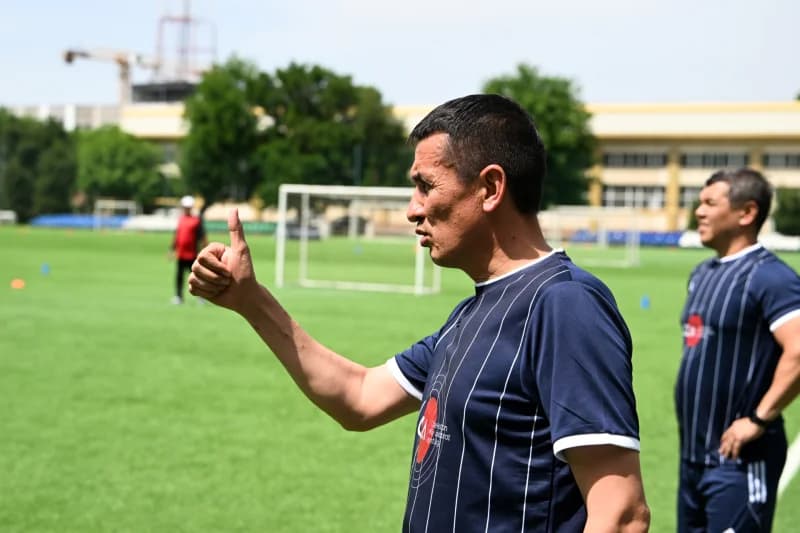 Coach giving thumbs up on pitch