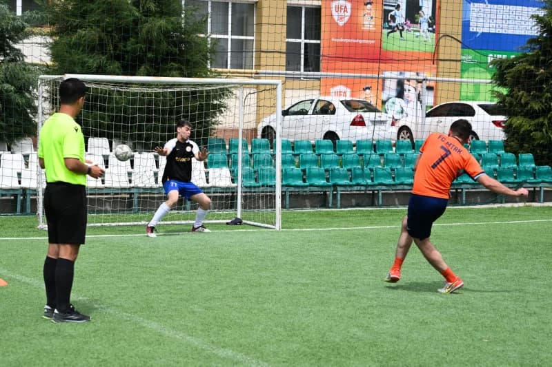 Futbol darvozasiga zarba beruvchi oʻyinchi