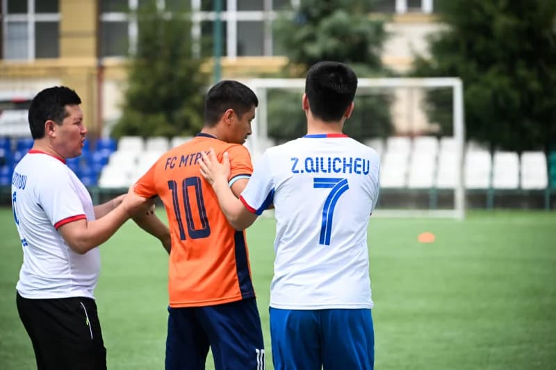Maydonda oʻzaro harakat qilayotgan futbolchilar.