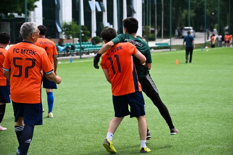 Amateur soccer players celebrating on pitch
