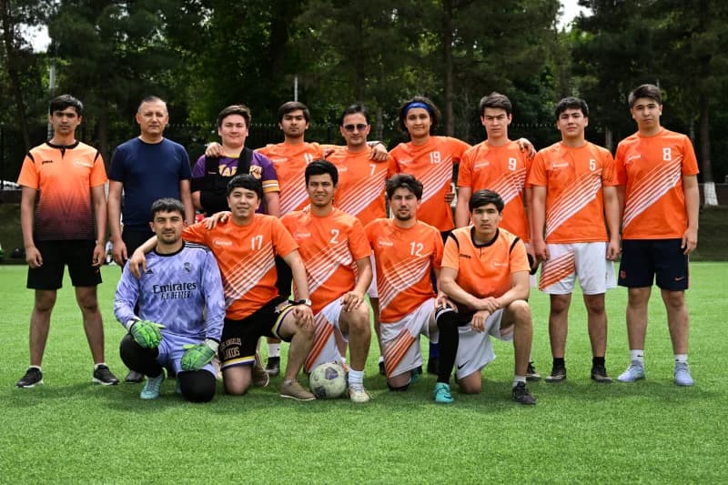 Soccer team posing on grass field