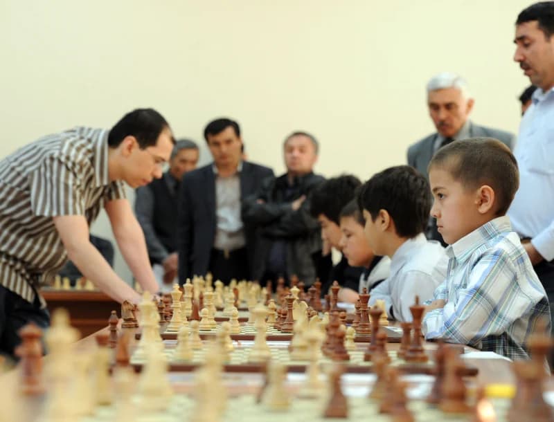 Люди играют в шахматы в комнате