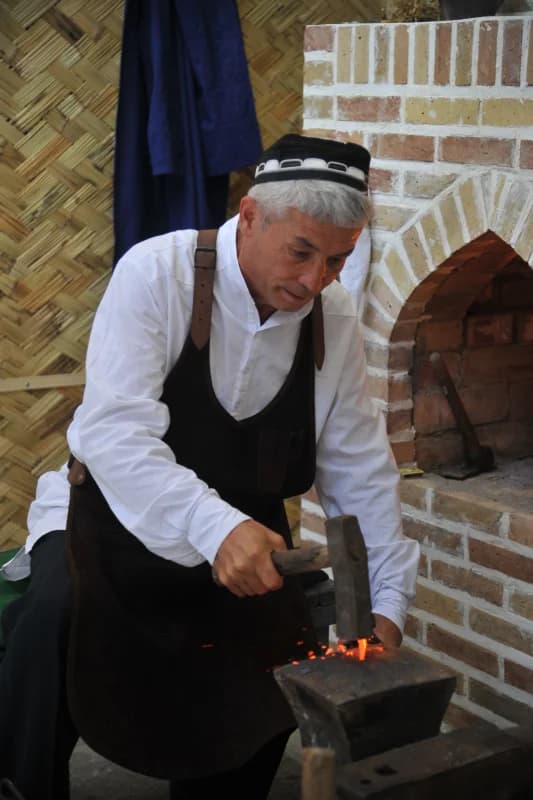 человек, ковающий горячий металл молотком