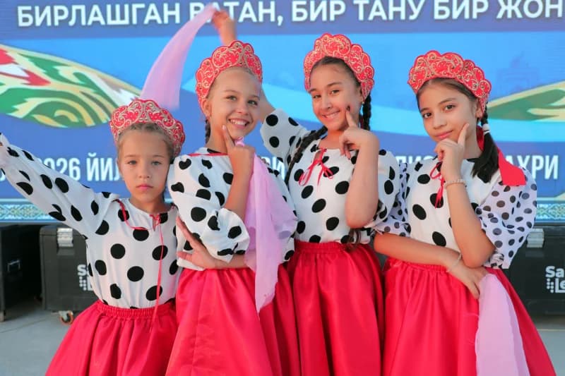 Четыре молодые девушки позируют в похожих народных костюмах